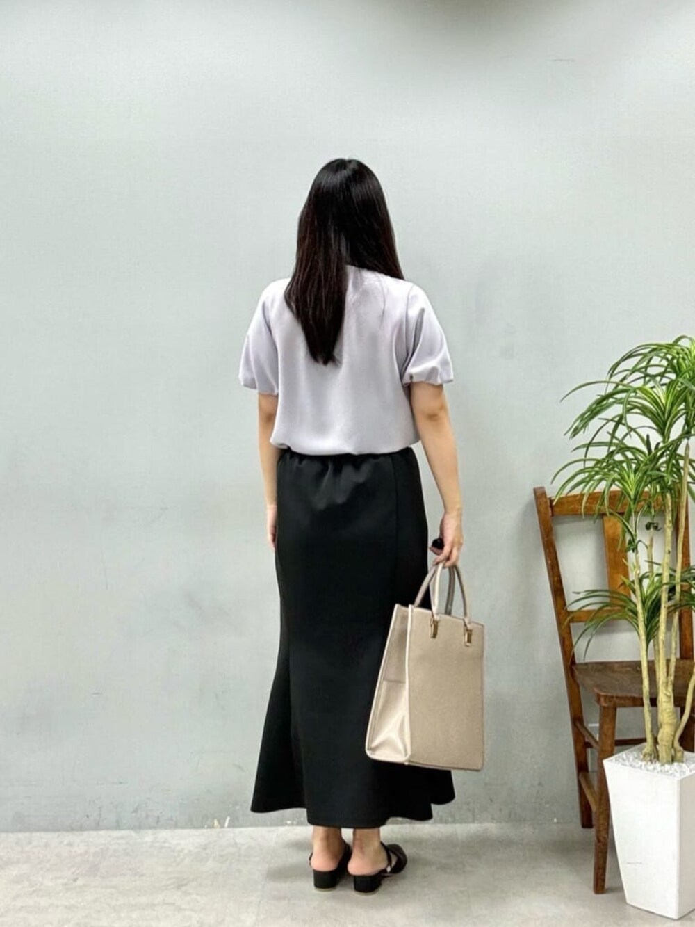 ブラック系のスカート、ベージュ系のシャツ/ブラウスを着用したレディースの夏コーディネートの3枚目の写真