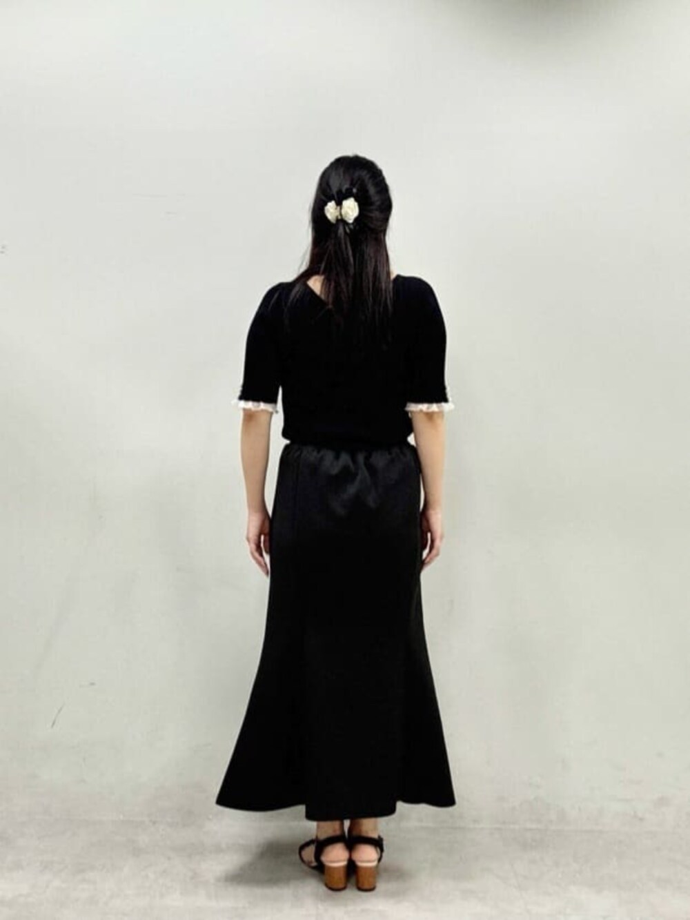 ブラック系のスカート、ブラック系のニット/セーターを着用したレディースの夏コーディネートの3枚目の写真