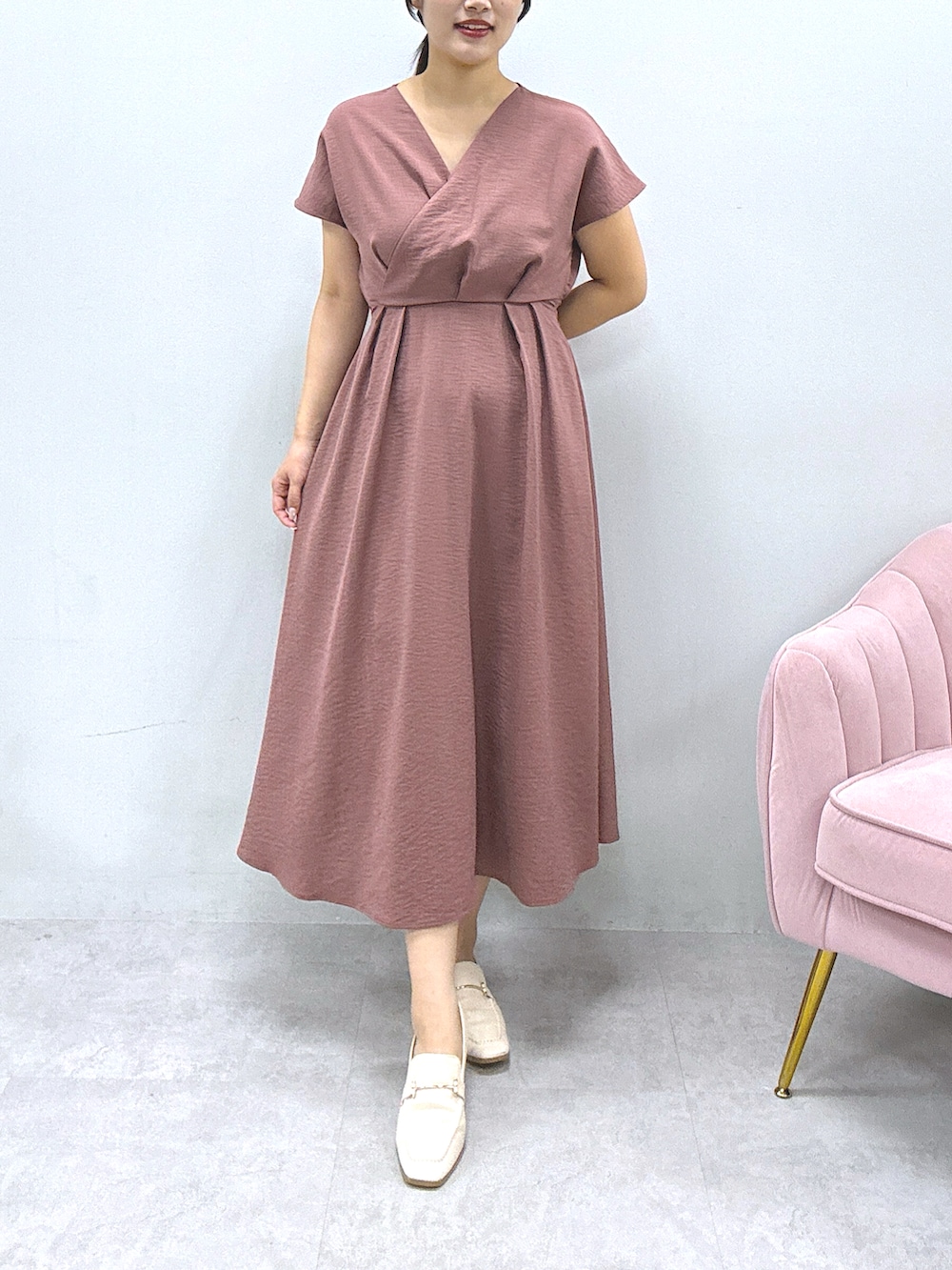 ピンク系のワンピース、ホワイト系のカーディガン/ボレロを着用したレディースの冬コーディネートの2枚目の写真