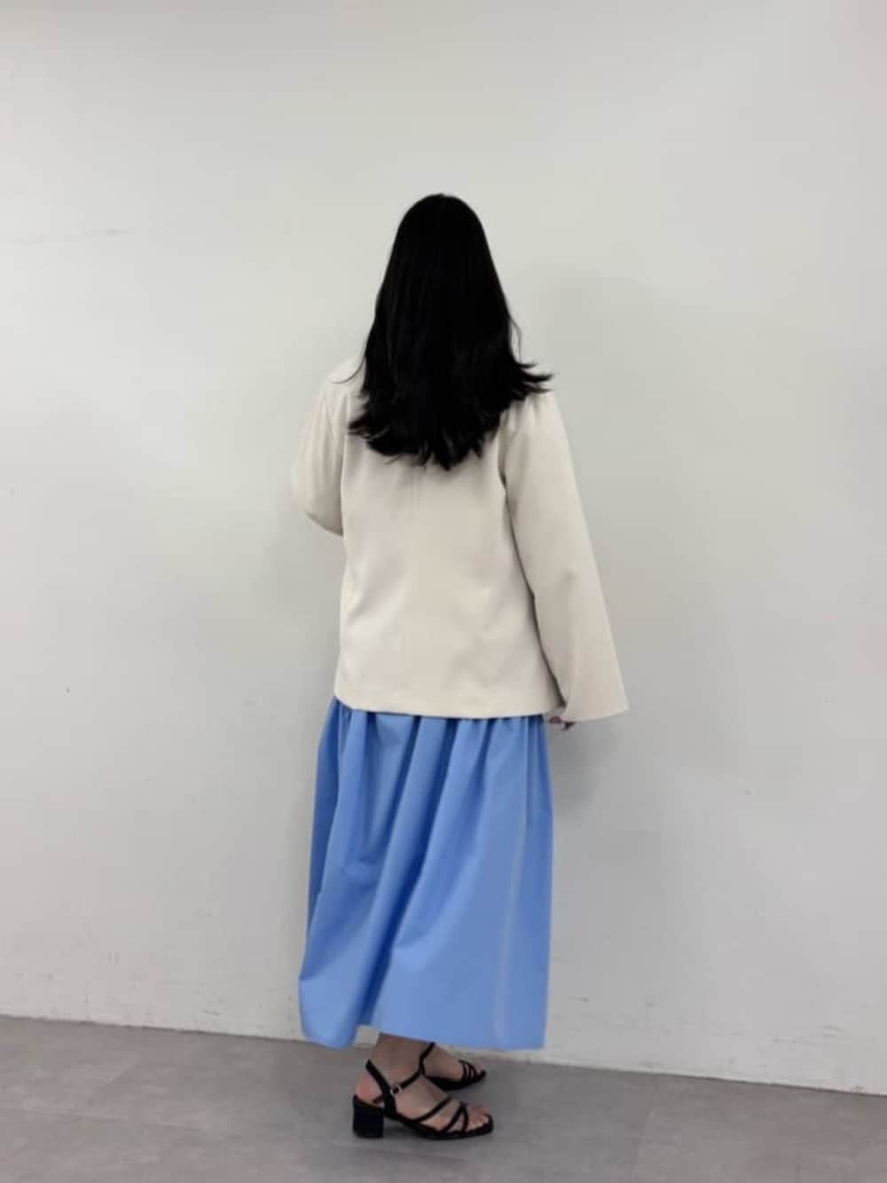 ホワイト系のテーラードジャケット、ブルー系のシャツワンピースを着用したレディースの春コーディネートの4枚目の写真