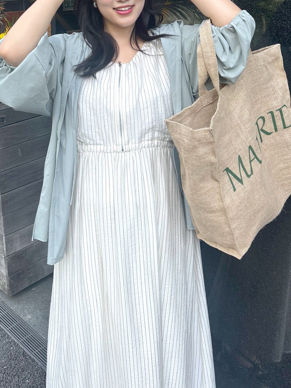 ベージュ系のワンピース、ブラック系のサンダルを着用したレディースの春コーディネートの4枚目の写真