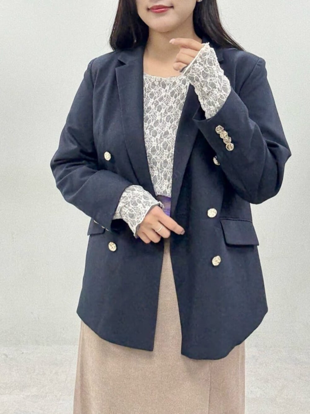 ブラウン系のスカート、ブルー系のテーラードジャケット、グレー系のTシャツ/カットソーを着用したレディースの秋コーディネートの4枚目の写真