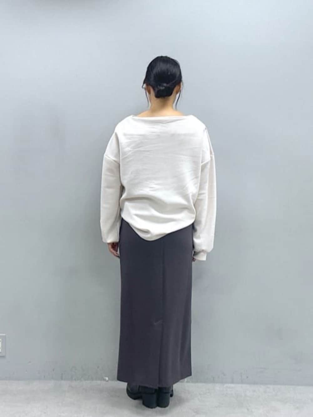 グレー系のスカート、ホワイト系のスウェットを着用したレディースの秋コーディネートの3枚目の写真