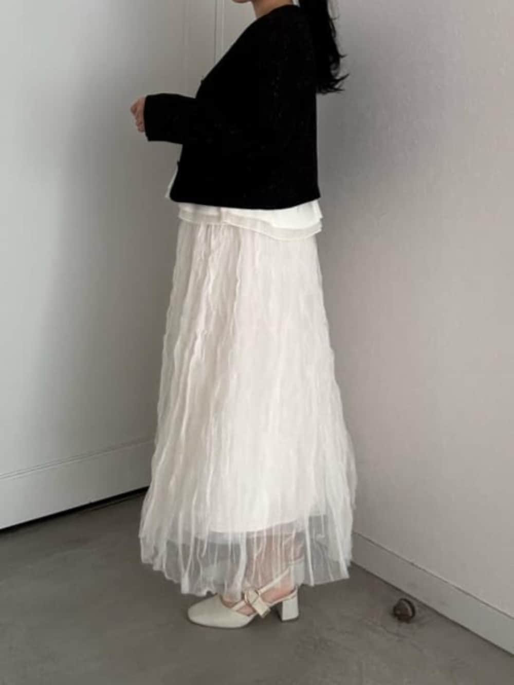 ブラック系のニット/セーター、ホワイト系のスカートを着用したレディースの冬コーディネートの3枚目の写真