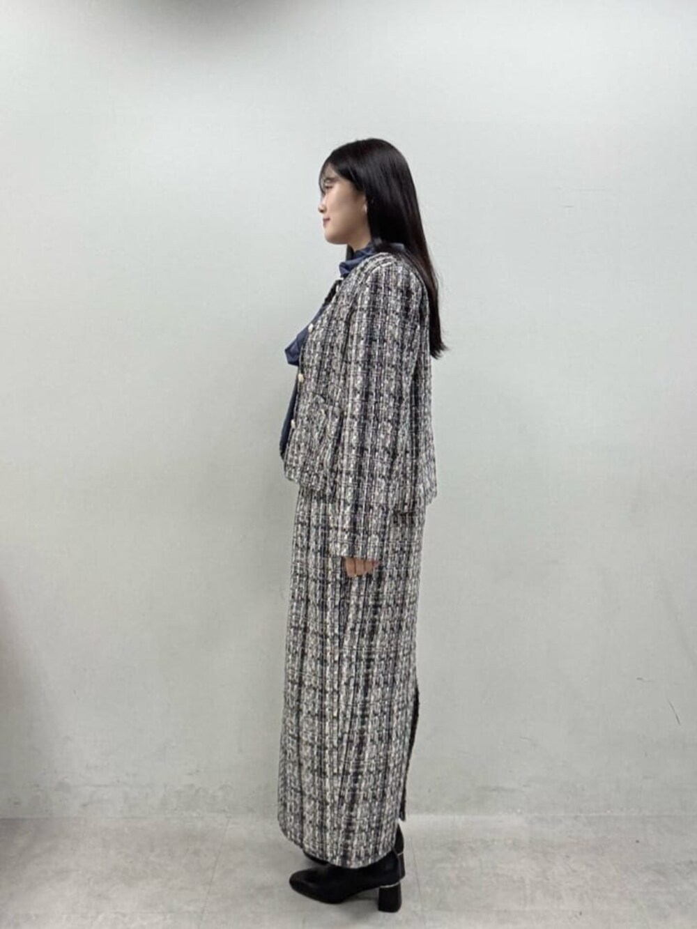 グレー系のスカート、グレー系のノーカラージャケット、ブルー系のシャツ/ブラウスを着用したレディースの秋コーディネートの3枚目の写真