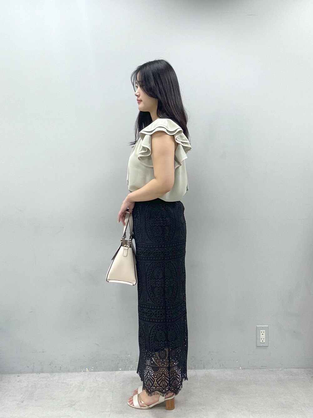 ブラック系のスカート、グリーン系のシャツ/ブラウスを着用したレディースの春コーディネートの2枚目の写真