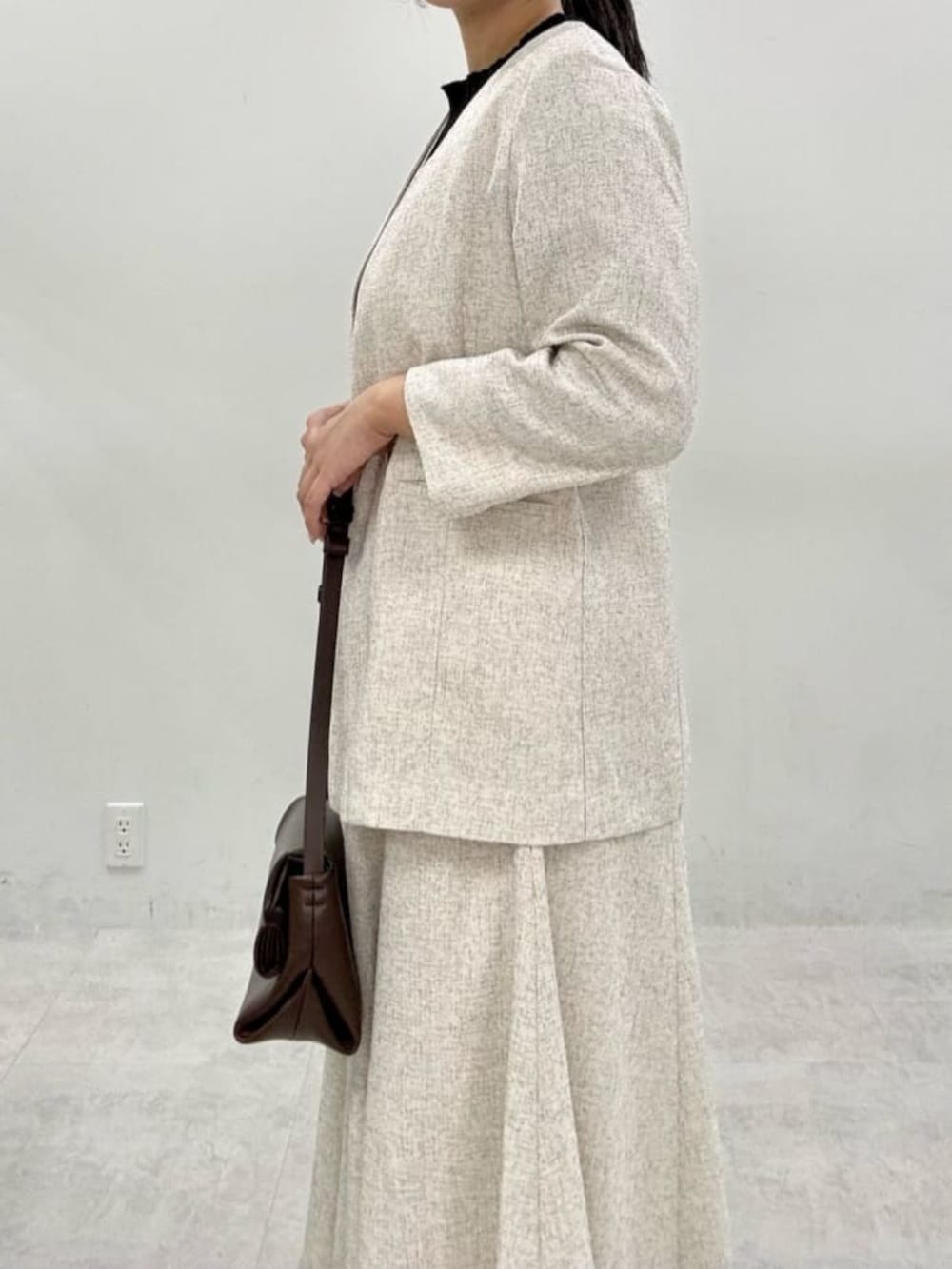 ブラック系のニット/セーター、ホワイト系のワンピース、ホワイト系のノーカラージャケットを着用したレディースの秋コーディネートの5枚目の写真