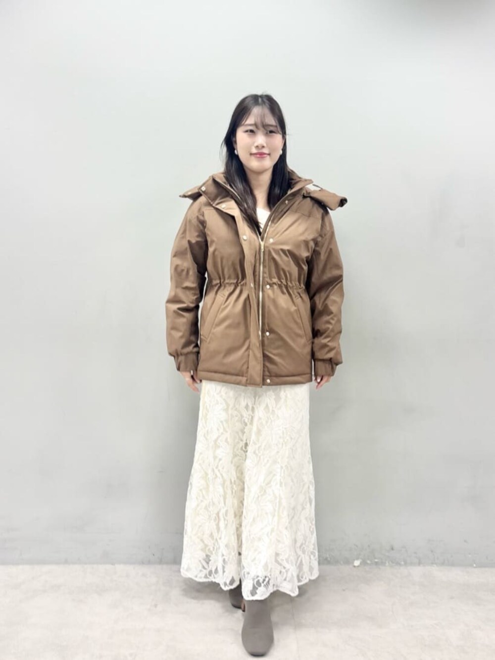 ホワイト系のニット/セーター、ブラウン系のダウンジャケット/コートを着用したレディースの秋コーディネートの4枚目の写真