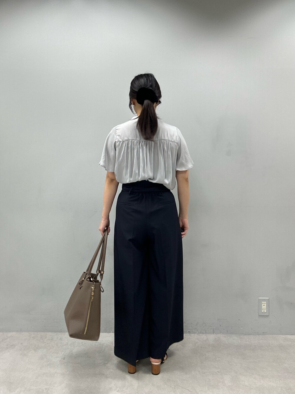 ブラウン系のショルダーバッグ、ブルー系のその他パンツ、グレー系のシャツ/ブラウスを着用したレディースの春コーディネートの3枚目の写真