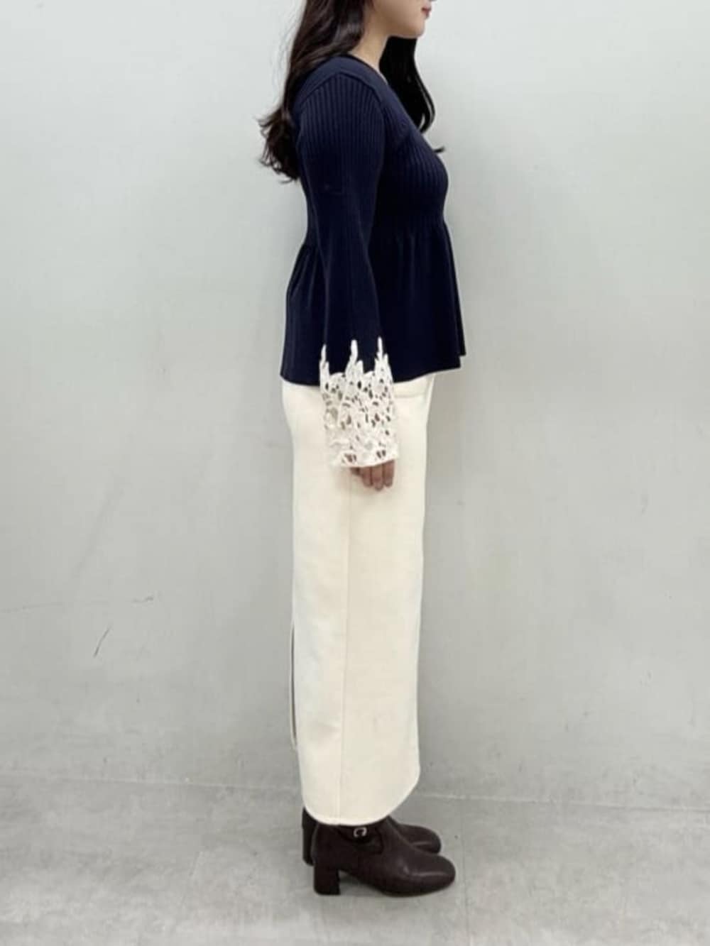 ホワイト系のスカート、ブルー系のニット/セーターを着用したレディースの秋コーディネートの2枚目の写真