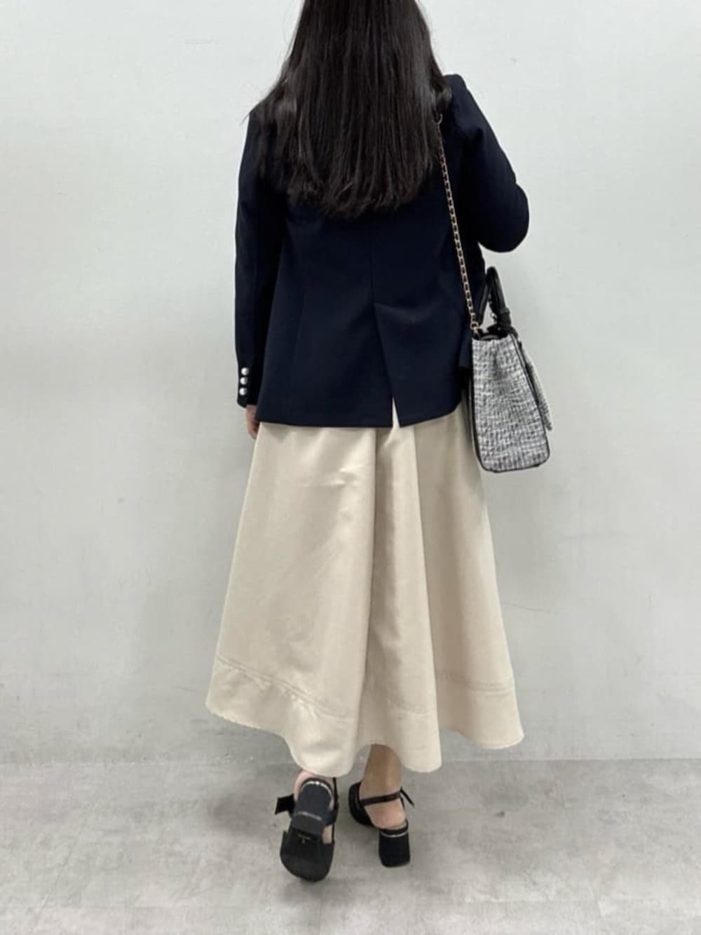 ブルー系のテーラードジャケット、ブラック系のサンダル、ブラック系のハンドバッグを着用したレディースの冬コーディネートの5枚目の写真