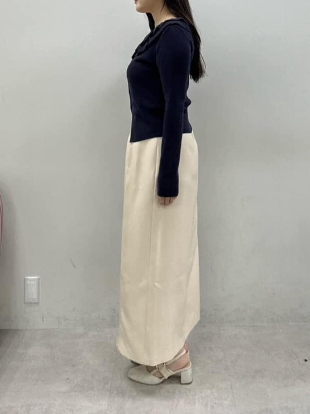 ホワイト系のサンダル、ブルー系のカーディガン/ボレロ、ブラック系のハンドバッグを着用したレディースの冬コーディネートの2枚目の写真