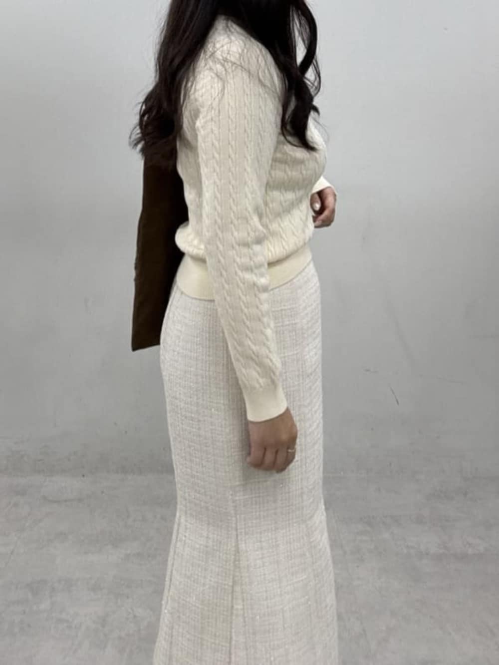 ホワイト系のスカート、ブラウン系のトートバッグ、ホワイト系のニット/セーターを着用したレディースの冬コーディネートの3枚目の写真