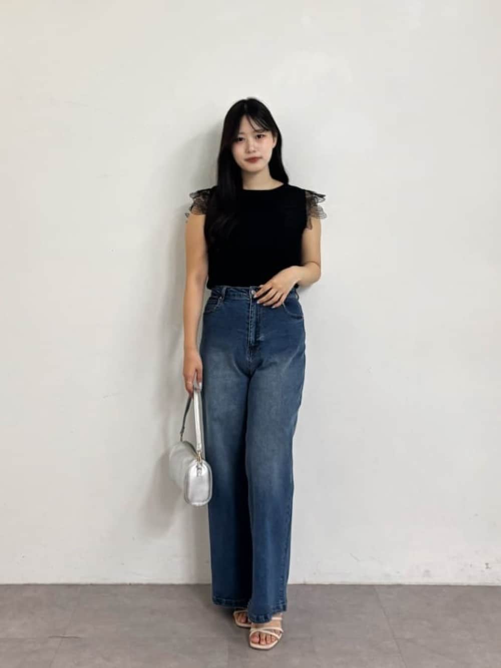 ブルー系のデニムパンツ、ブラック系のニット/セーターを着用したレディースの夏コーディネートの2枚目の写真