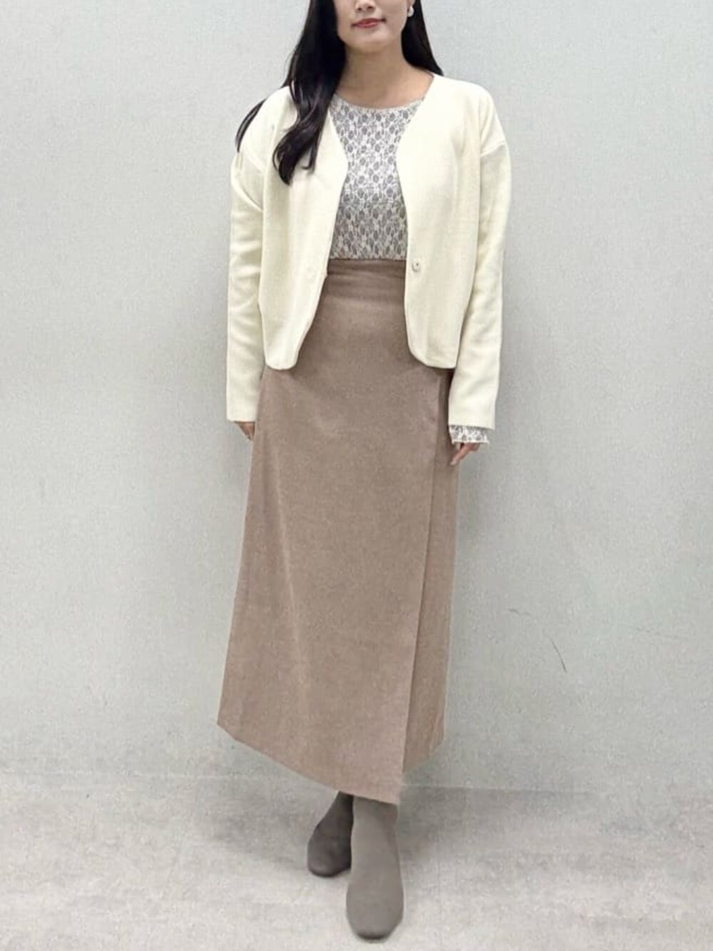 ブラウン系のスカート、グレー系のTシャツ/カットソー、ホワイト系のカーディガン/ボレロを着用したレディースの秋コーディネートの4枚目の写真