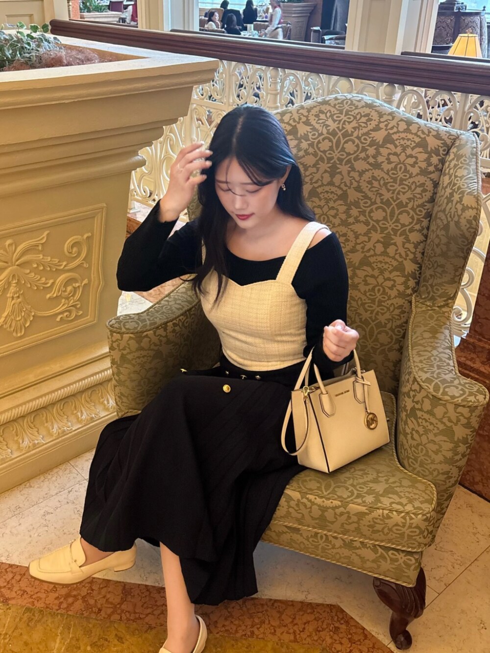 ホワイト系のシャツ/ブラウス、ブラック系のニット/セーター、ブラック系のスカートを着用したレディースの秋コーディネートの2枚目の写真