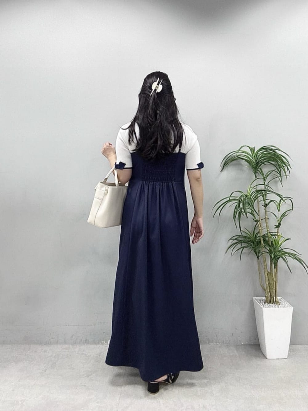 ブルー系のワンピース、ホワイト系のニット/セーターを着用したレディースの春コーディネートの3枚目の写真