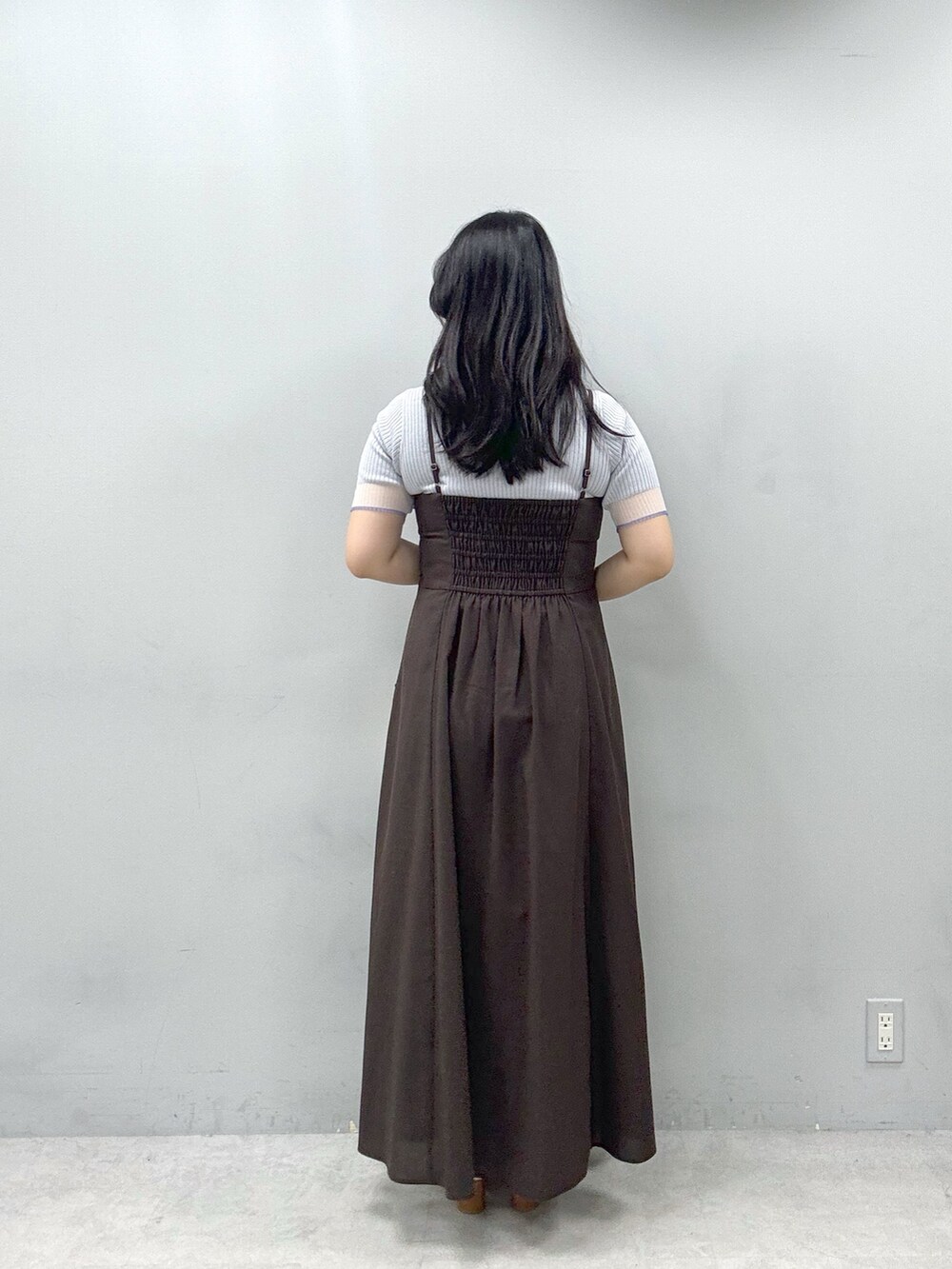 ブラウン系のワンピース、ホワイト系のショルダーバッグ、グレー系のニット/セーターを着用したレディースの春コーディネートの3枚目の写真