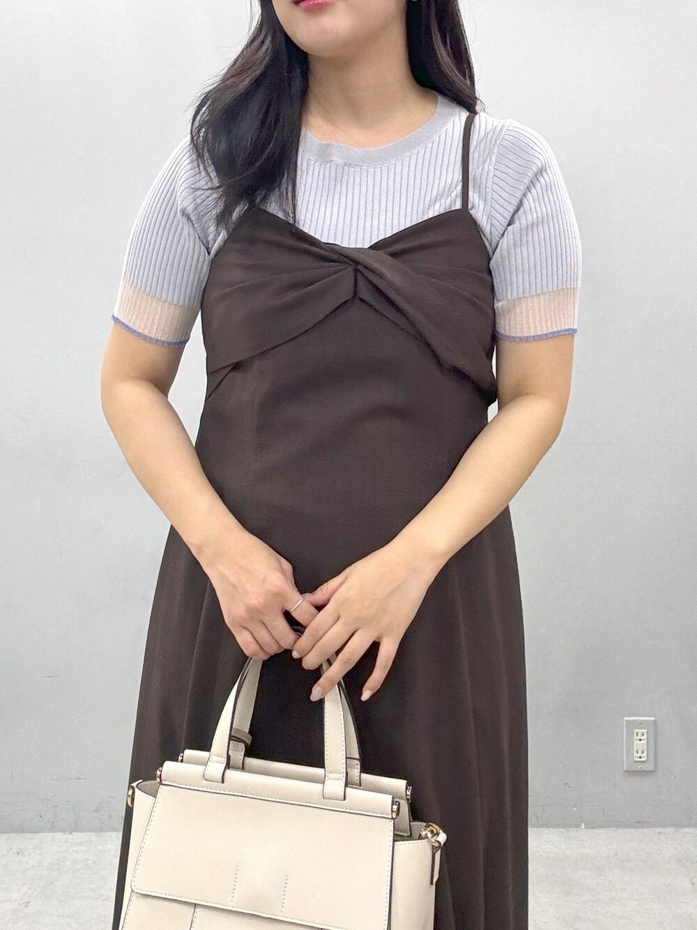 ブラウン系のワンピース、ホワイト系のショルダーバッグ、グレー系のニット/セーターを着用したレディースの春コーディネートの4枚目の写真