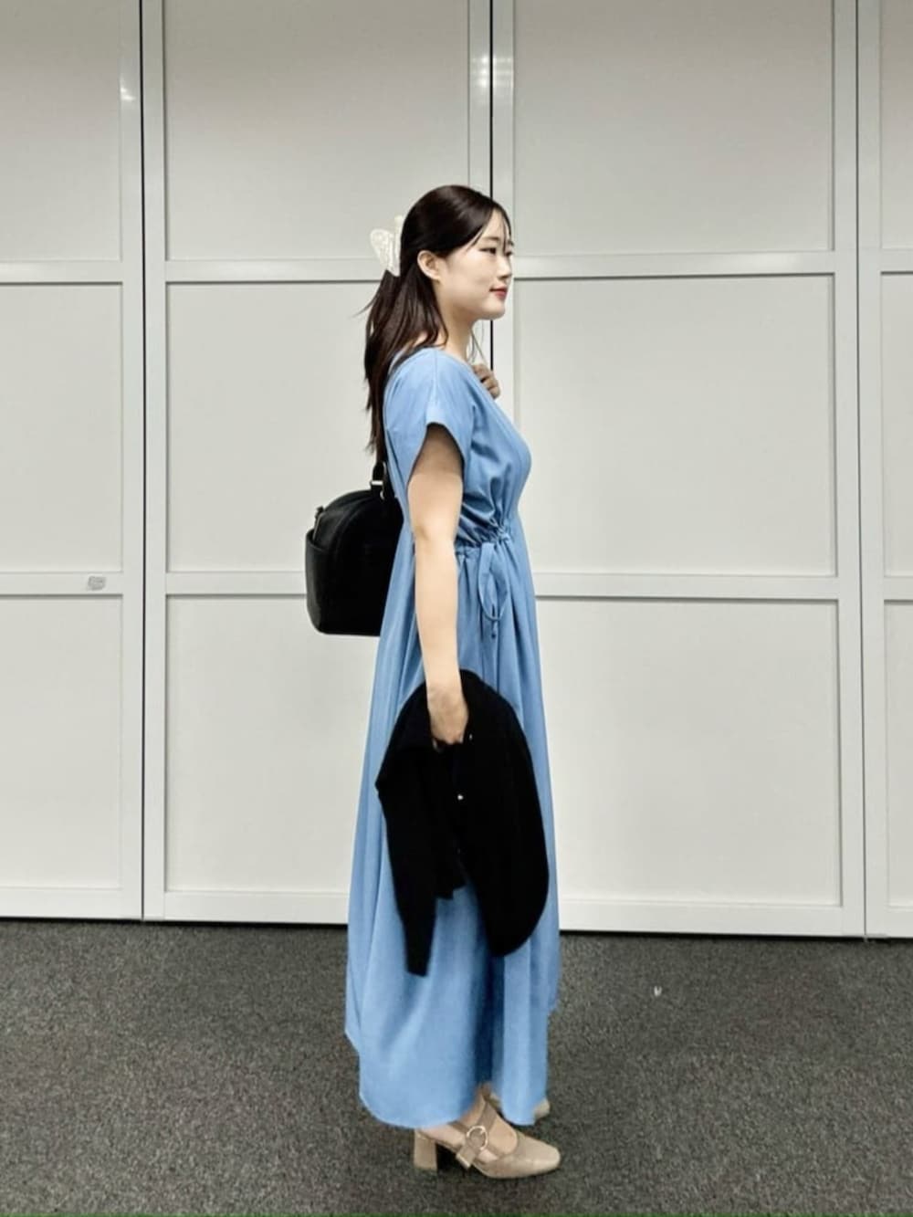 ブラック系のボストンバッグ、ブルー系のワンピース、ブルー系のカーディガン/ボレロを着用したレディースの秋コーディネートの3枚目の写真