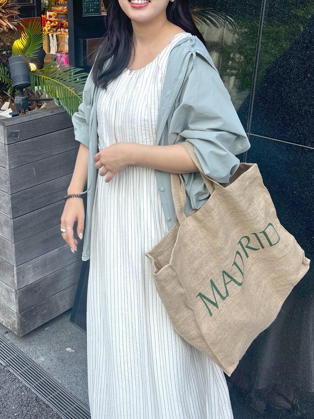 ベージュ系のワンピース、ブラック系のサンダルを着用したレディースの春コーディネートの3枚目の写真