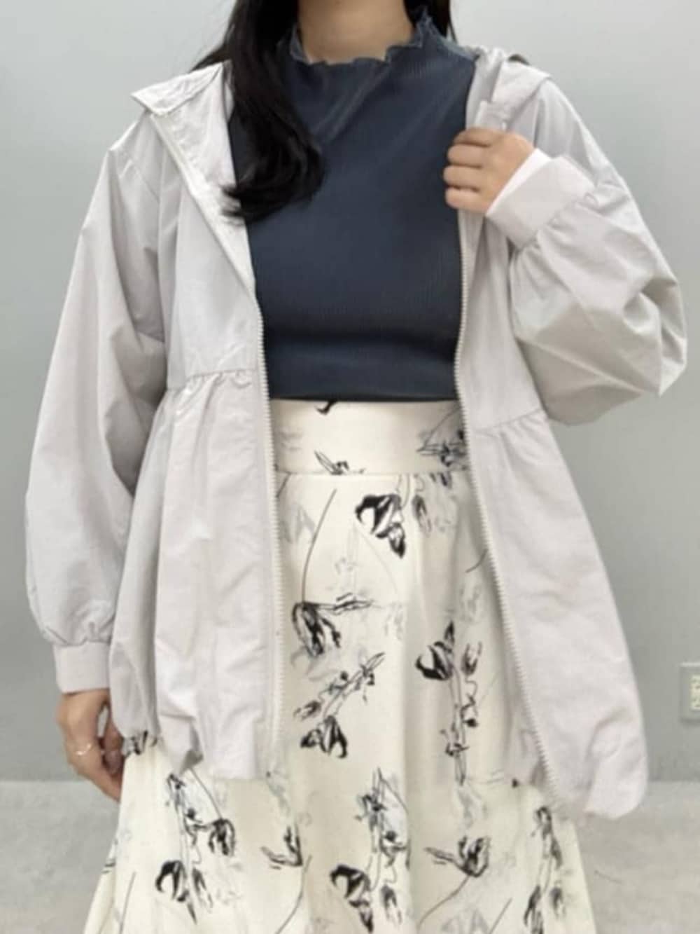 ホワイト系のスカート、グレー系のTシャツ/カットソー、グレー系のマウンテンパーカーを着用したレディースの冬コーディネートの4枚目の写真