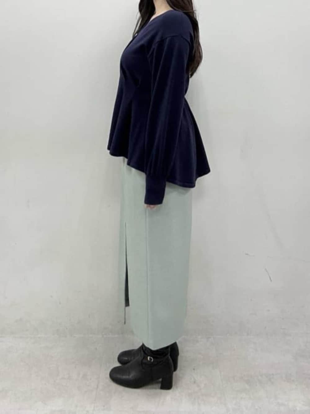 グリーン系のスカート、ブルー系のニット/セーターを着用したレディースの冬コーディネートの2枚目の写真