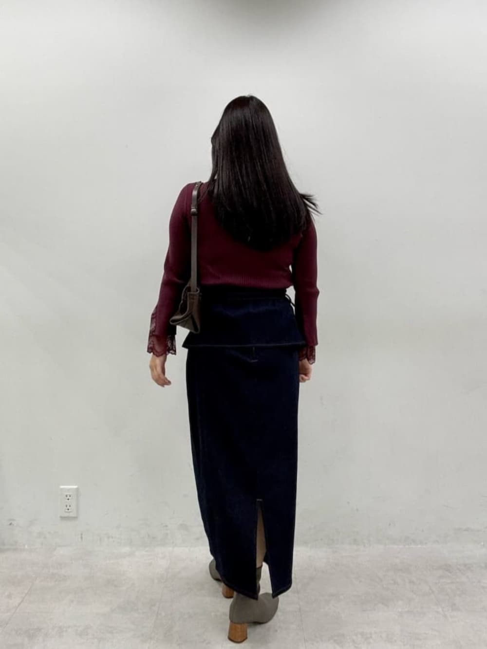 ブルー系のスカート、レッド系のニット/セーターを着用したレディースの秋コーディネートの3枚目の写真