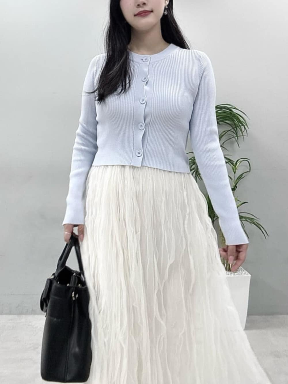 ホワイト系のスカート、ブルー系のカーディガン/ボレロを着用したレディースの春コーディネートの2枚目の写真