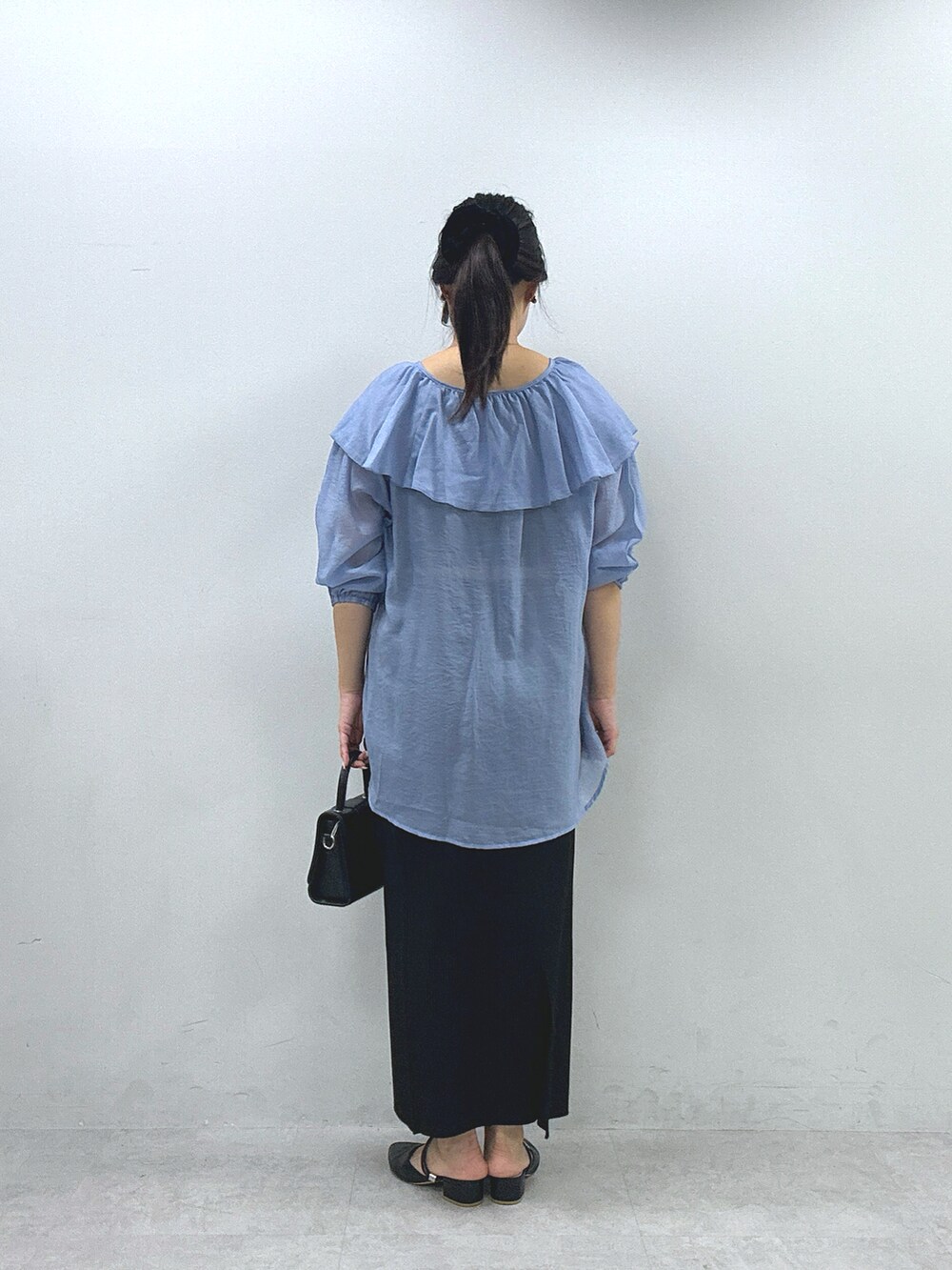 ブラック系のスカート、ブルー系のシャツ/ブラウスを着用したレディースの春コーディネートの4枚目の写真