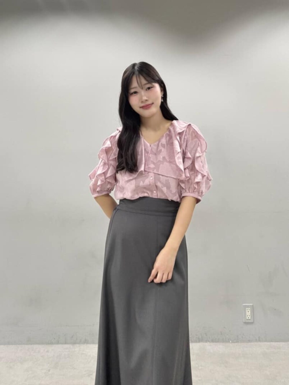 グレー系のスカート、ピンク系のシャツ/ブラウスを着用したレディースの春コーディネートの2枚目の写真