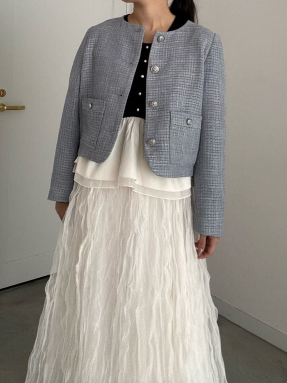 ブラック系のニット/セーター、ホワイト系のサンダル、ホワイト系のスカートを着用したレディースの冬コーディネートの3枚目の写真