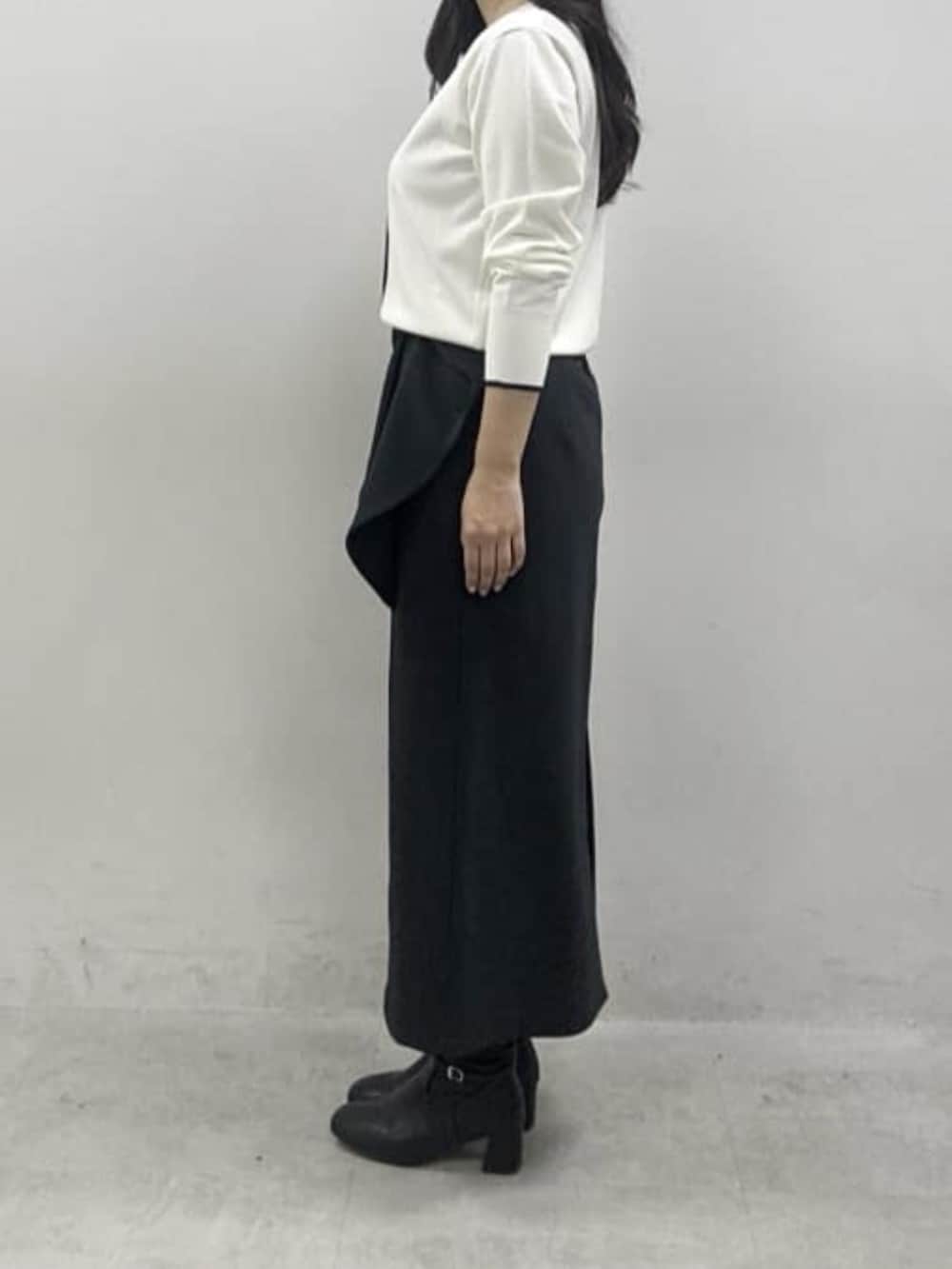 ホワイト系のカーディガン/ボレロ、ブラック系のスカートを着用したレディースの冬コーディネートの2枚目の写真