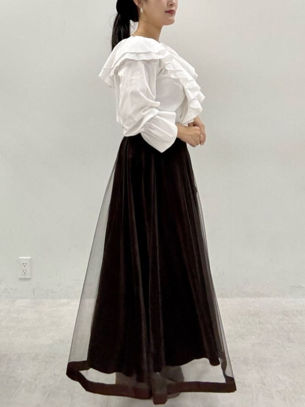 ブラウン系のスカート、グレー系のテーラードジャケットを着用したレディースの秋コーディネートの7枚目の写真