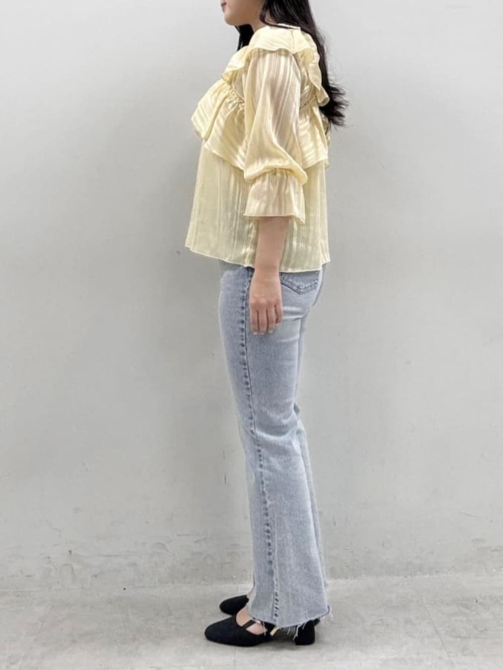 イエロー系のシャツ/ブラウス、ブルー系のデニムパンツを着用したレディースの冬コーディネートの2枚目の写真