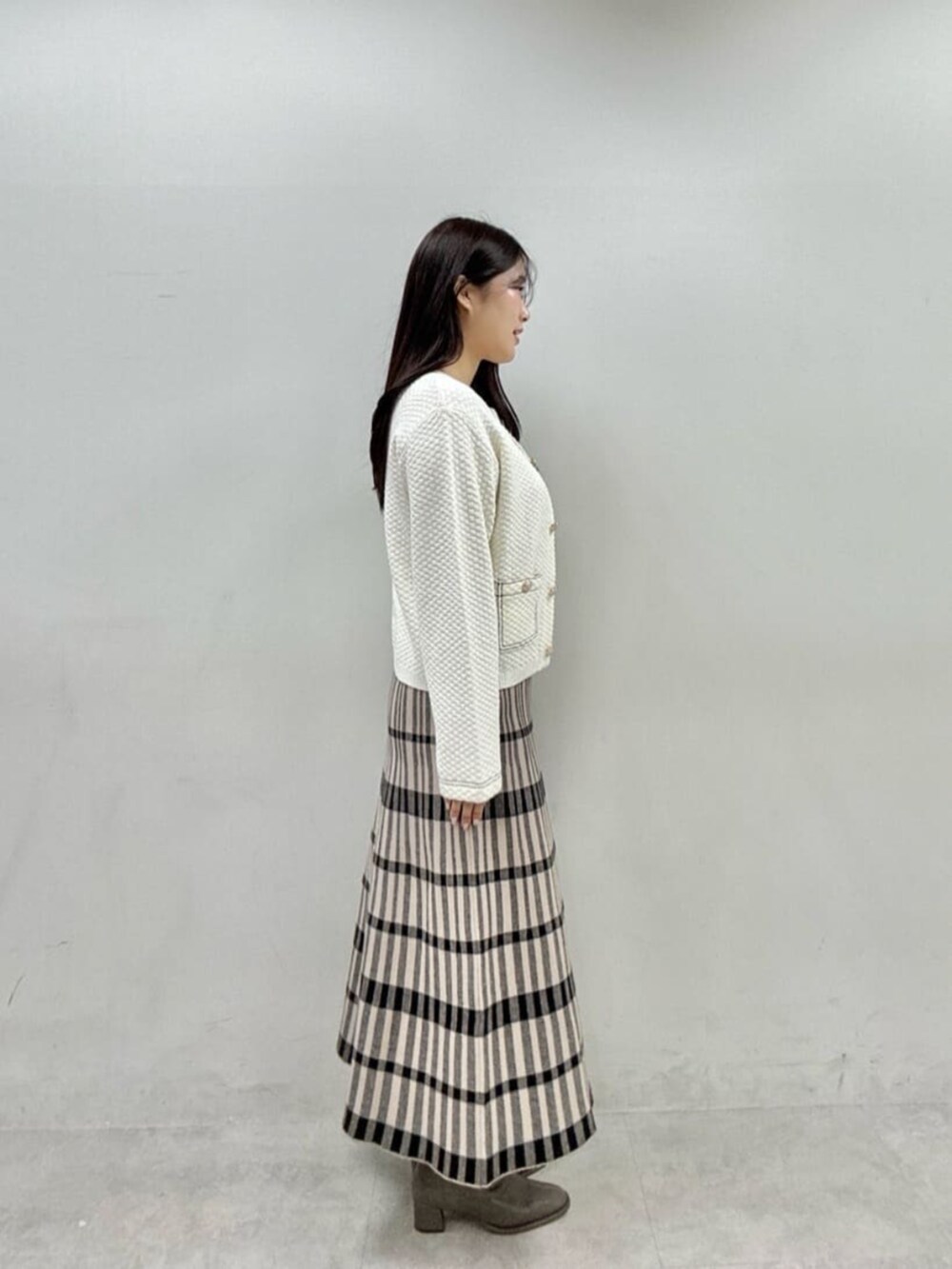 ベージュ系のワンピース、ホワイト系のニット/セーターを着用したレディースの秋コーディネートの3枚目の写真