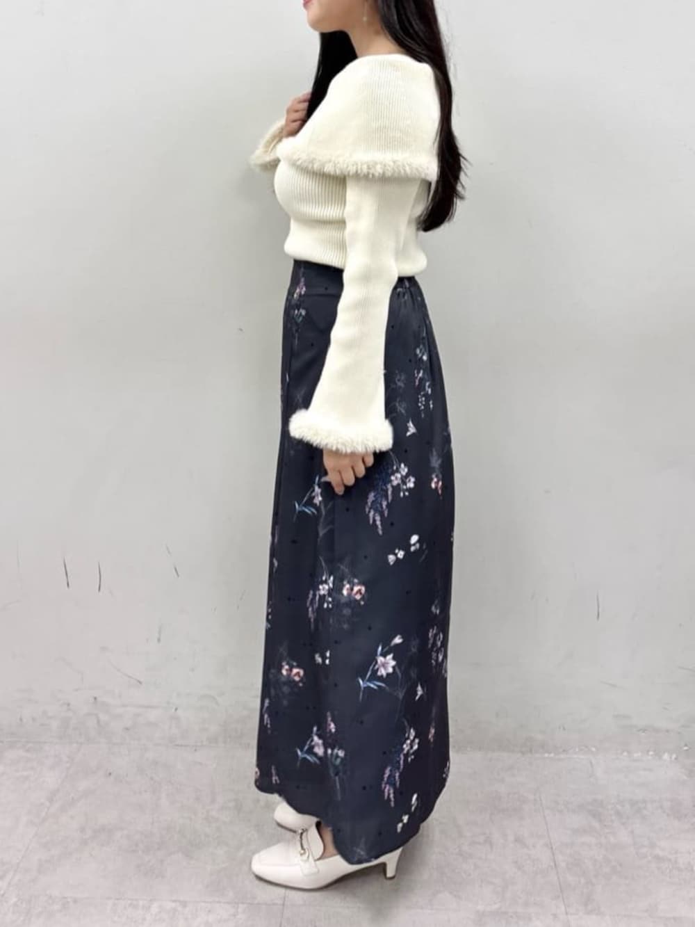 ベージュ系のニット/セーター、グレー系のスカートを着用したレディースの夏コーディネートの2枚目の写真