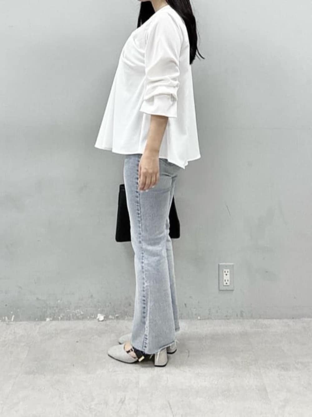 ブルー系のデニムパンツ、ブラック系のショルダーバッグ、ホワイト系のシャツ/ブラウスを着用したレディースの春コーディネートの2枚目の写真