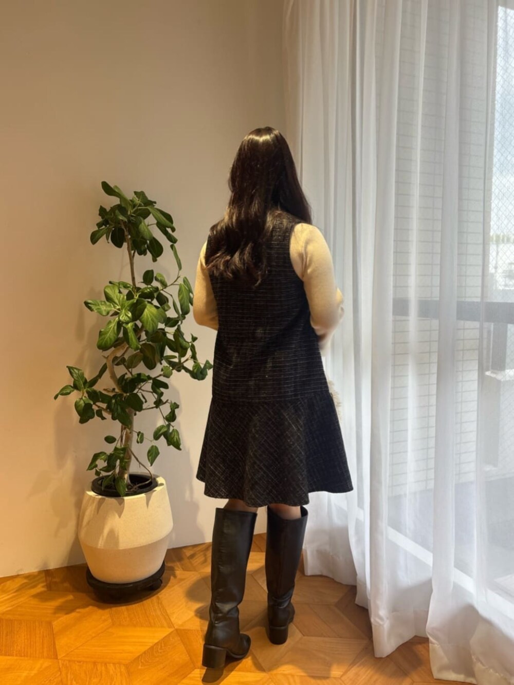 ブラック系のブーツ、ホワイト系のハンドバッグ、ホワイト系のニット/セーターを着用したレディースの秋コーディネートの3枚目の写真