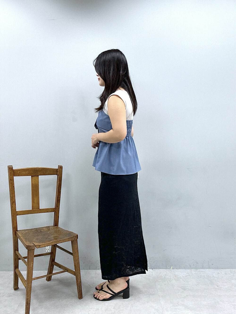 ブラック系のスカート、ブルー系のTシャツ/カットソー、ホワイト系のショルダーバッグを着用したレディースの春コーディネートの2枚目の写真