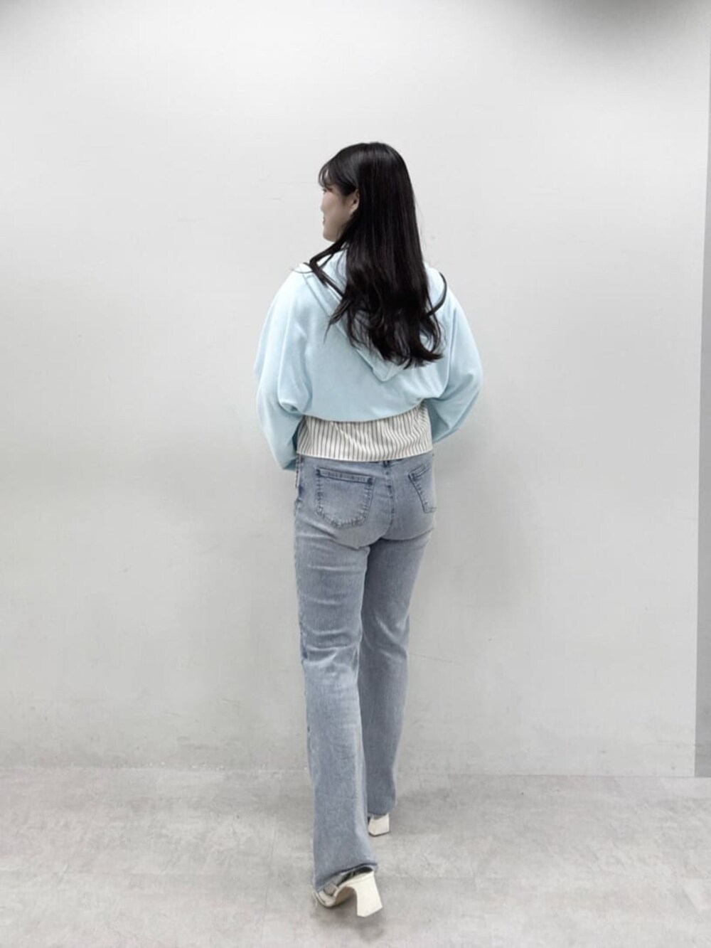ブルー系のデニムパンツ、ホワイト系の水着、ブルー系のタオルを着用したレディースの春コーディネートの3枚目の写真