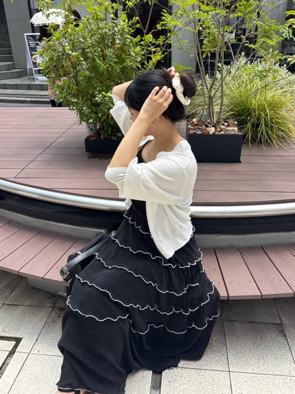 ホワイト系のカーディガン/ボレロ、ブラック系のワンピースを着用したレディースの夏コーディネートの4枚目の写真