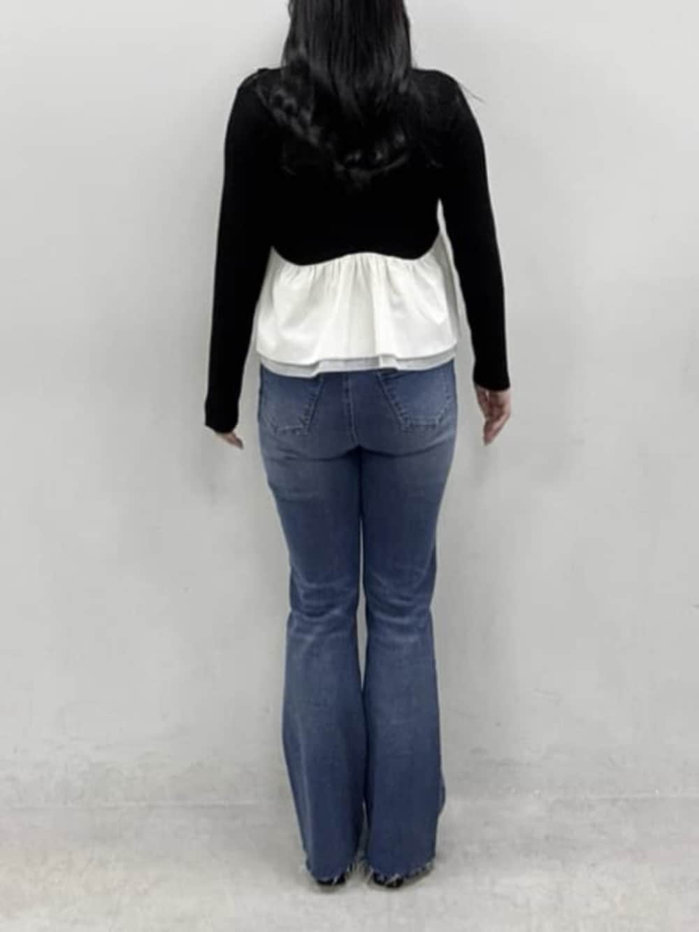 ブラック系のニット/セーター、ブルー系のデニムパンツ、ブラック系のその他シューズを着用したレディースの冬コーディネートの3枚目の写真