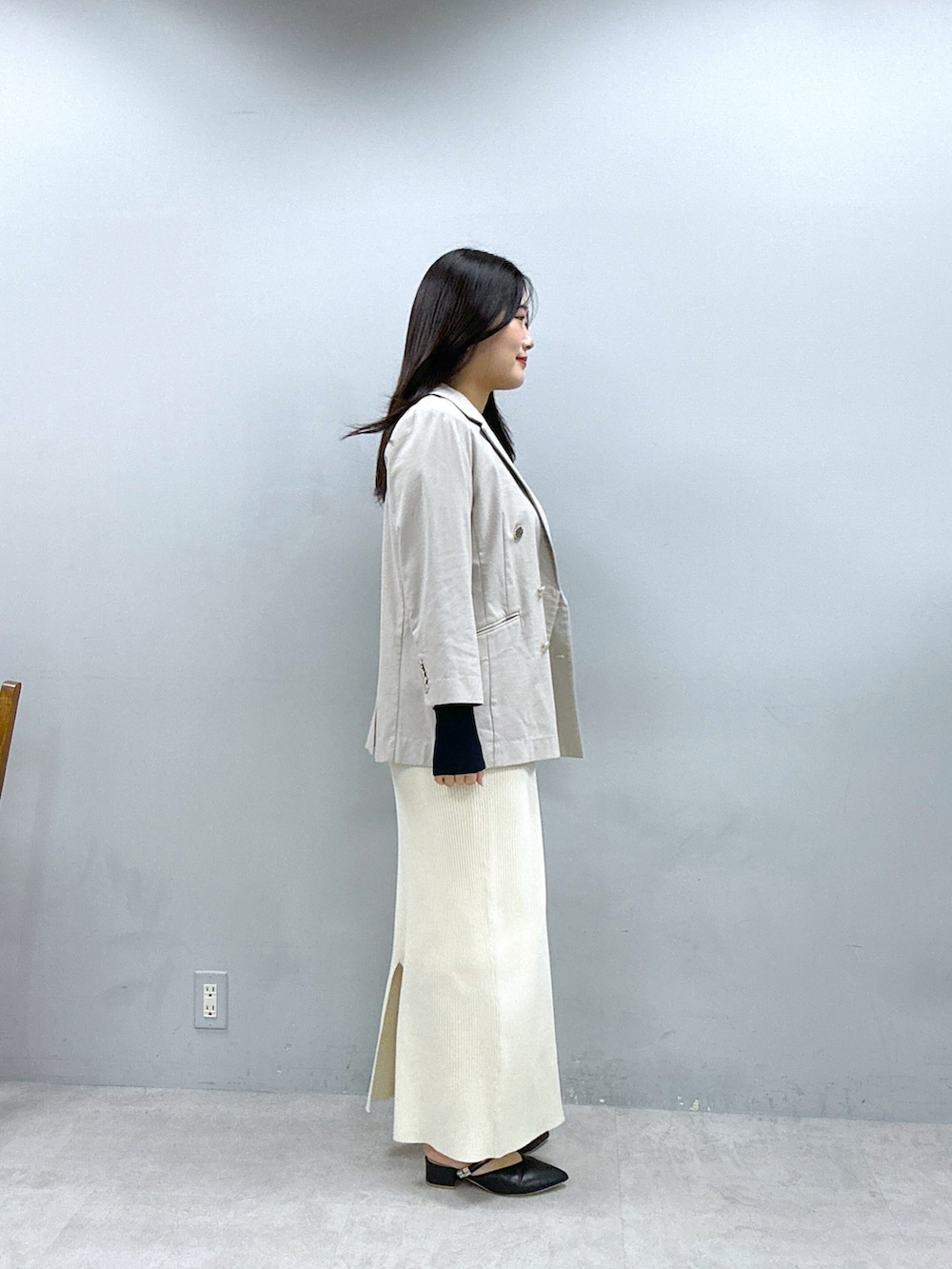 ホワイト系のスカート、ブルー系のニット/セーター、ベージュ系のブルゾンを着用したレディースの春コーディネートの2枚目の写真