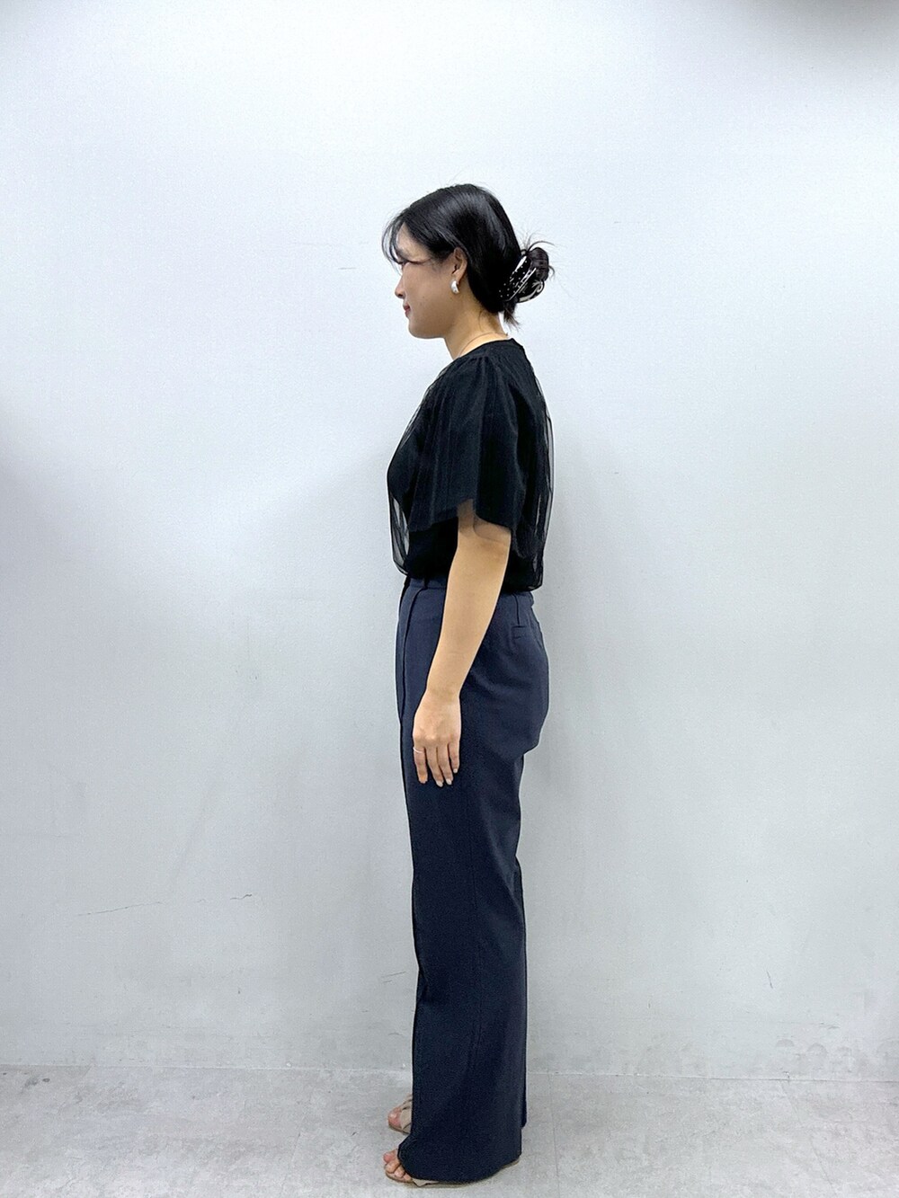 ブルー系のその他パンツ、ブラック系のニット/セーターを着用したレディースの春コーディネートの2枚目の写真