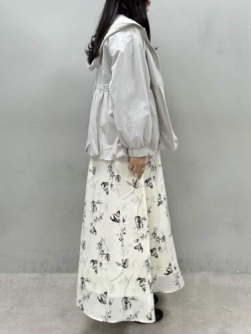 ホワイト系のスカート、グレー系のTシャツ/カットソー、グレー系のマウンテンパーカーを着用したレディースの冬コーディネートの2枚目の写真