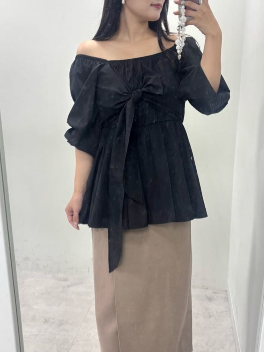 ブラウン系のスカート、ブラック系のシャツ/ブラウスを着用したレディースの秋コーディネートの5枚目の写真