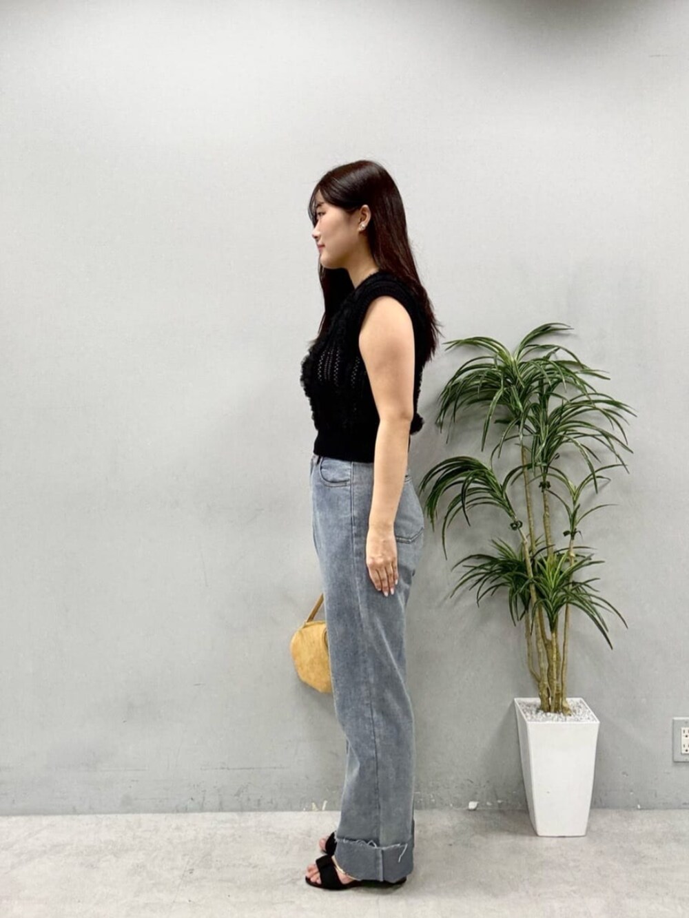 ブラック系のニット/セーター、イエロー系のショルダーバッグを着用したレディースの夏コーディネートの2枚目の写真