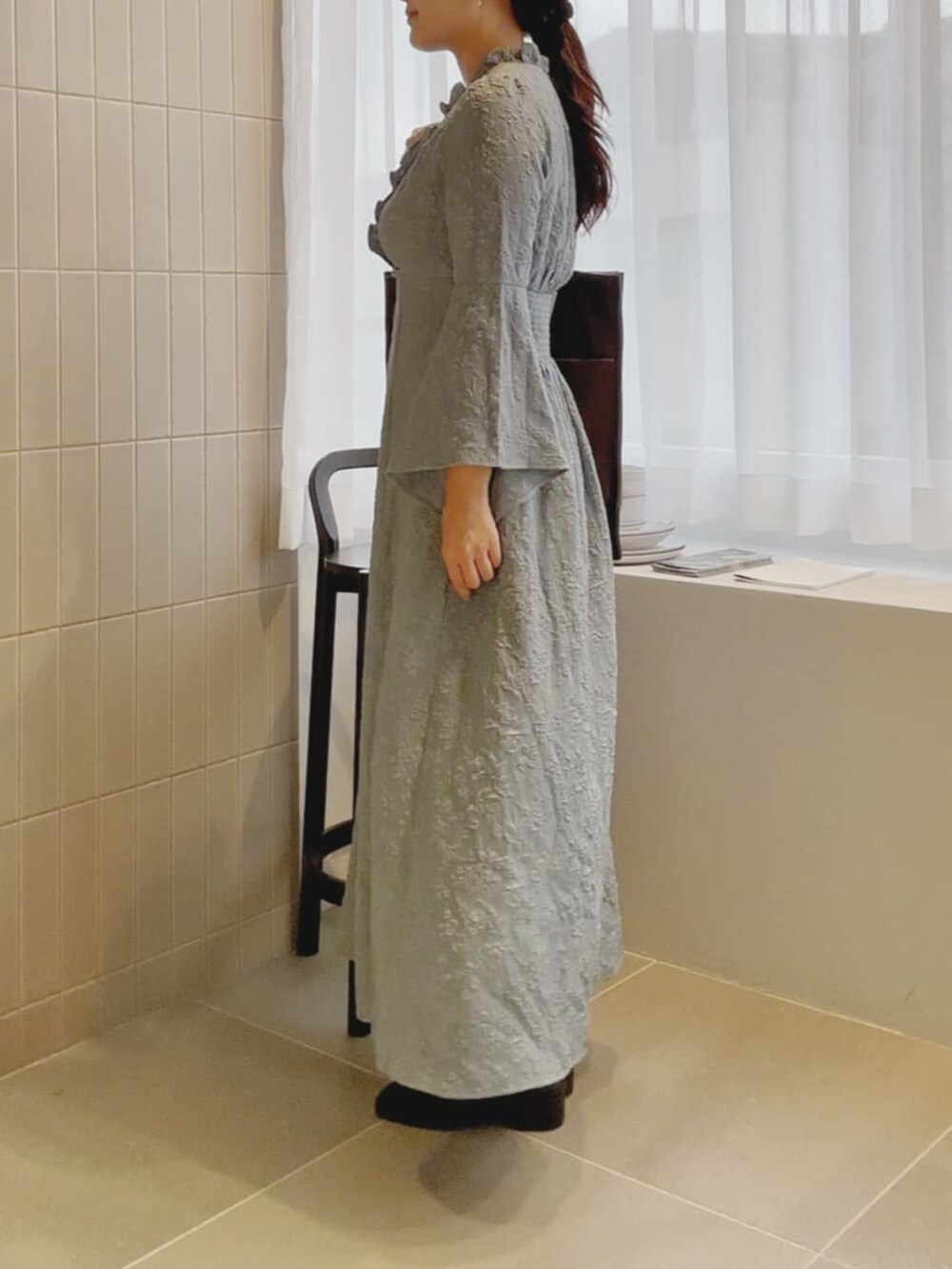 ブラウン系のトートバッグ、ブルー系のワンピースを着用したレディースの冬コーディネートの2枚目の写真