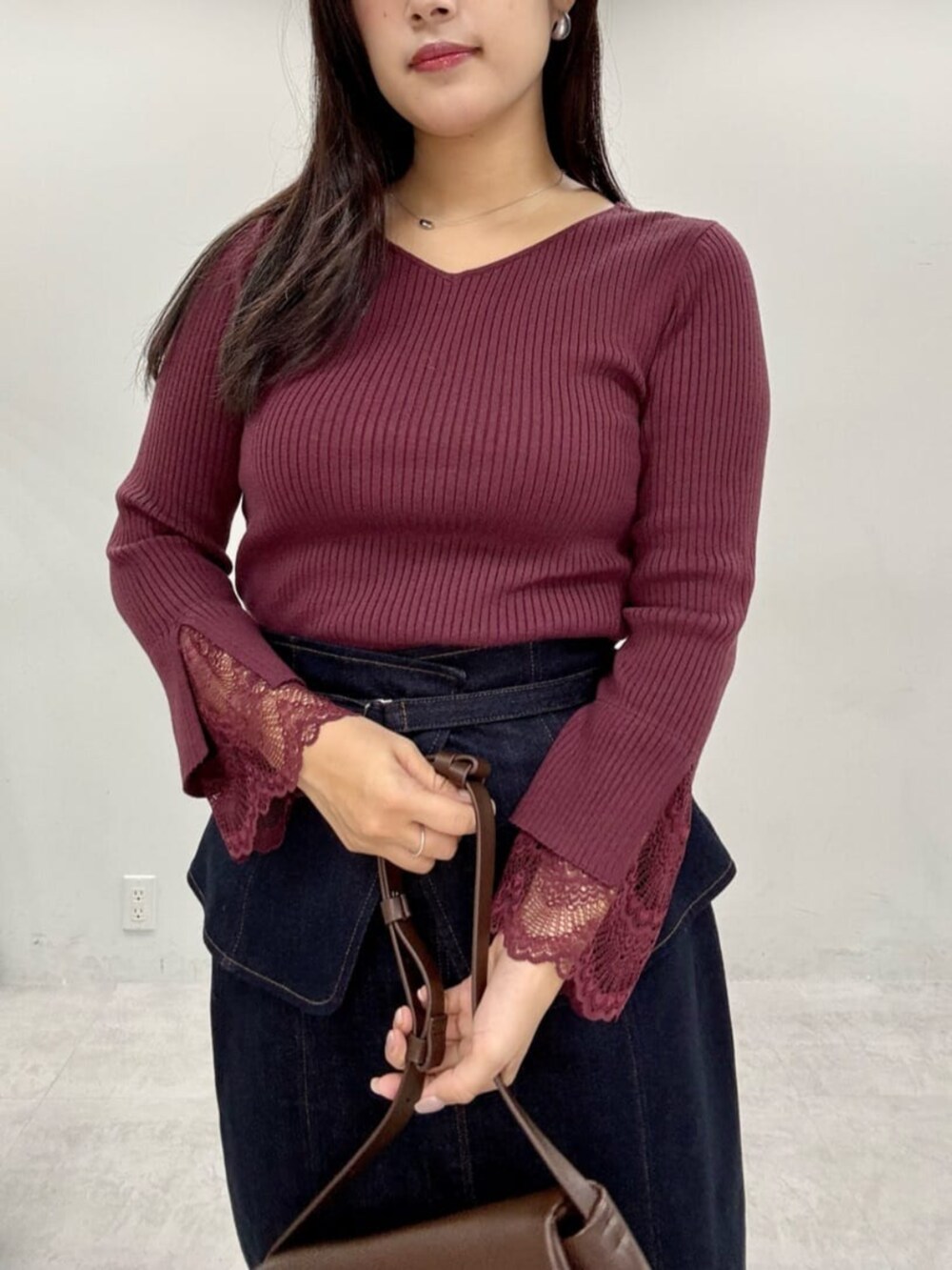 ブルー系のスカート、レッド系のニット/セーターを着用したレディースの秋コーディネートの4枚目の写真